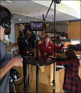 A woman in an MIT shirt being filmed by a crew.