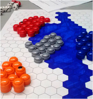 Colored pieces on a board of hexagons, many sided dice, and a sheet of rules.