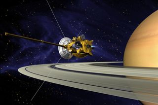 Artist's depiction of the Cassini spacecraft, with Saturn in the foreground and a dark blue, starry background.