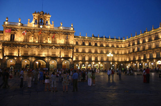 A photograph of the Plaza Mayor in Salamanca, Spain at dusk.